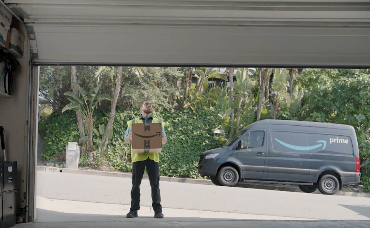 May delivering an Amazon box via Amazon key to a garage with Amazon truck in the background