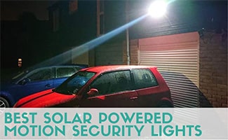 A red car parked next to a blue car at night, shone on by a security light. Caption: Best Solar Powered Motion Security Lights