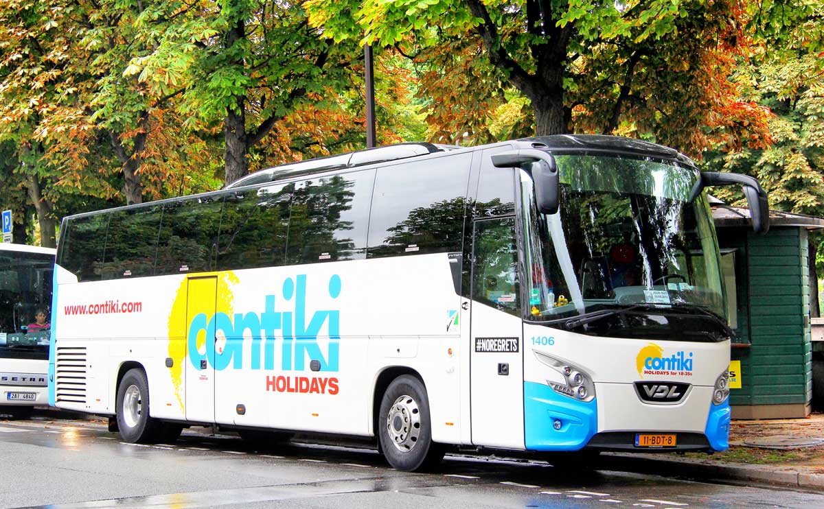 Contiki tour bus parked in Paris France in autumn with leaves in background.