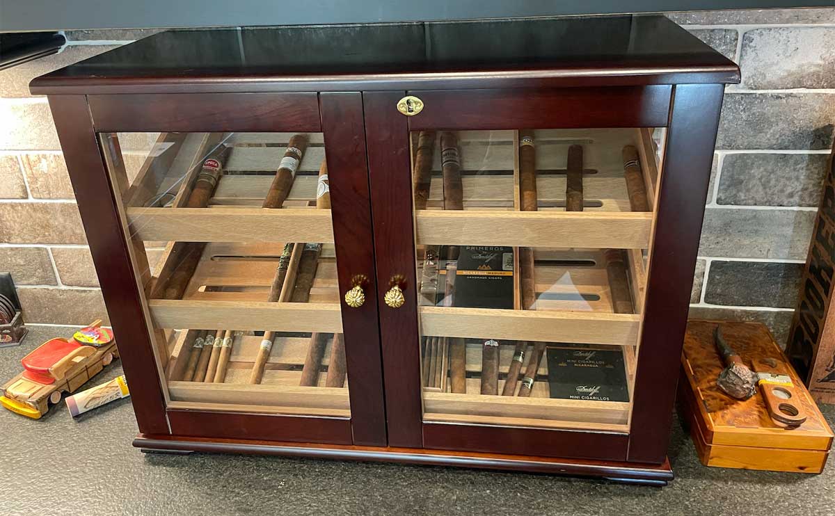 Countertop display humidor with a few cigars on display.