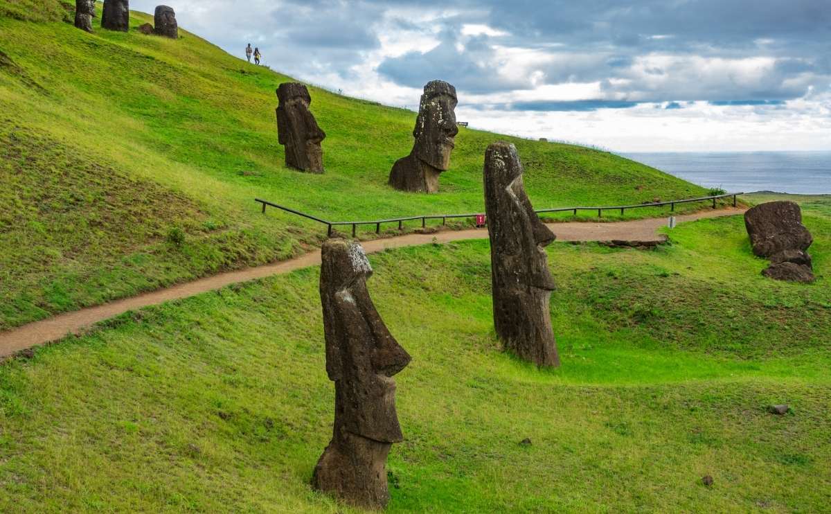 Crooked Moais in a hillside quarry with a path for tourists.