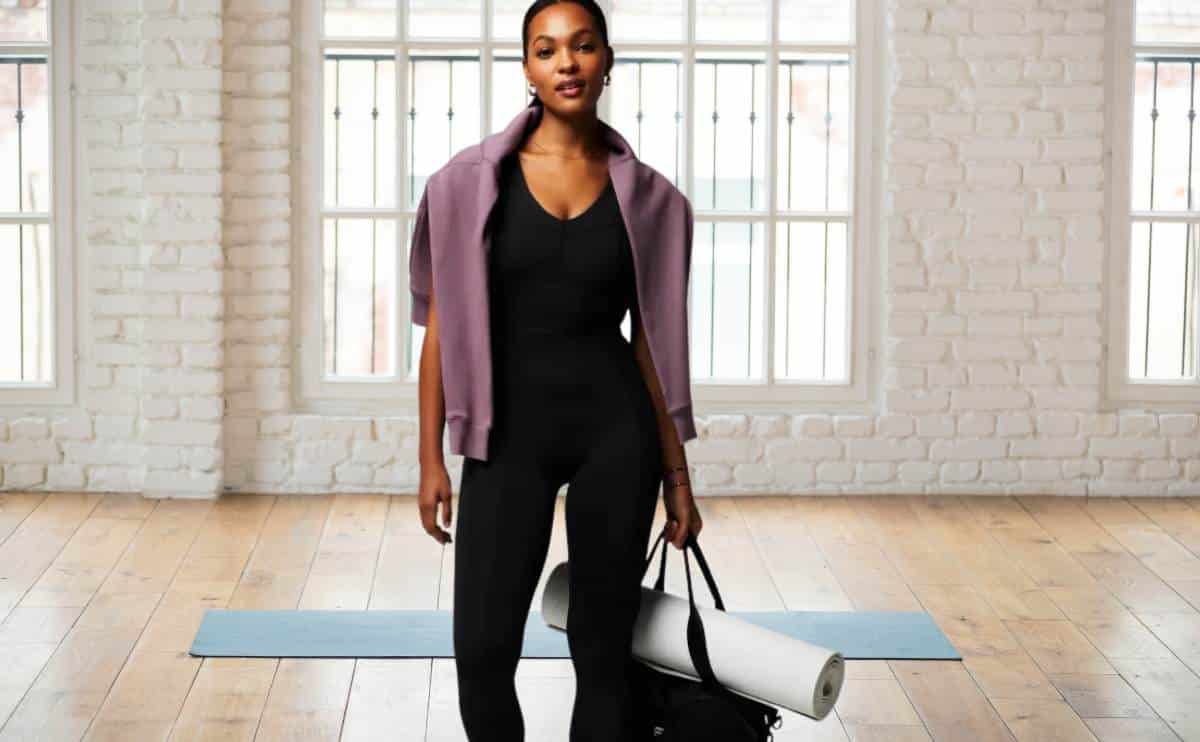 Dark skinned woman in yoga studio wearing Fabletics outfit.