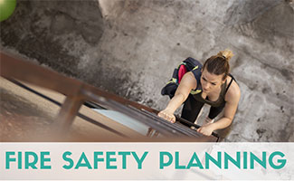 Young woman wearing a backpack descending down a fire escape ladder (view from above). Caption: Fire Safety Planning