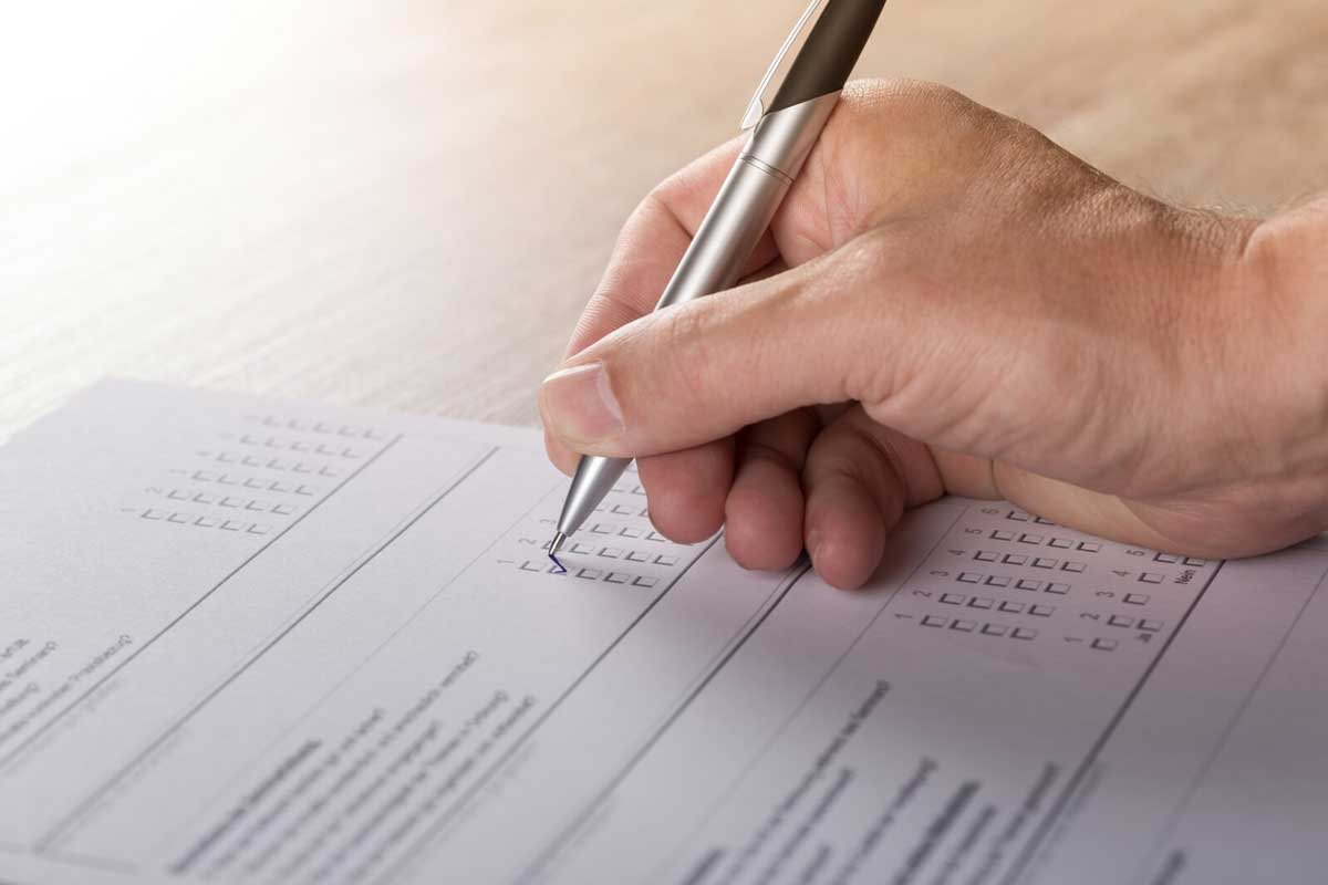 Close-up of hand filling out police report for stolen package.