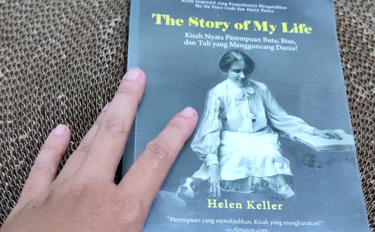 Hand holding Helen Keller's book "The Story of My Life."