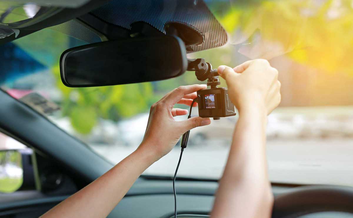 Hands adjusting security camera inside car