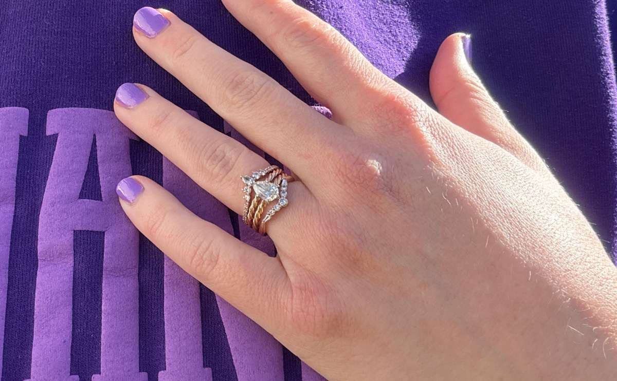 Kimberly's engagement rings stacked on hear hand up close.