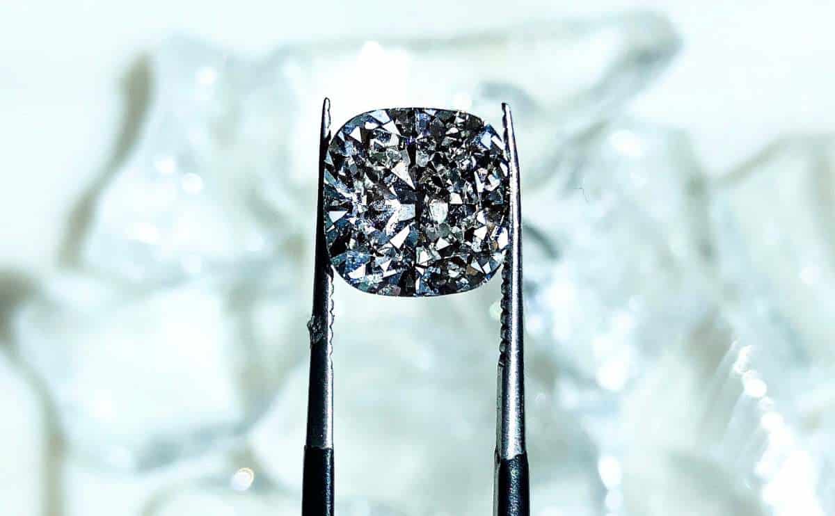 A lab grown diamond in tweezers.