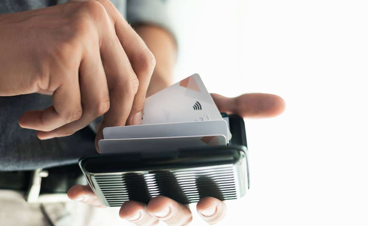 man holding contactless credit card in a wallet with rfid protection