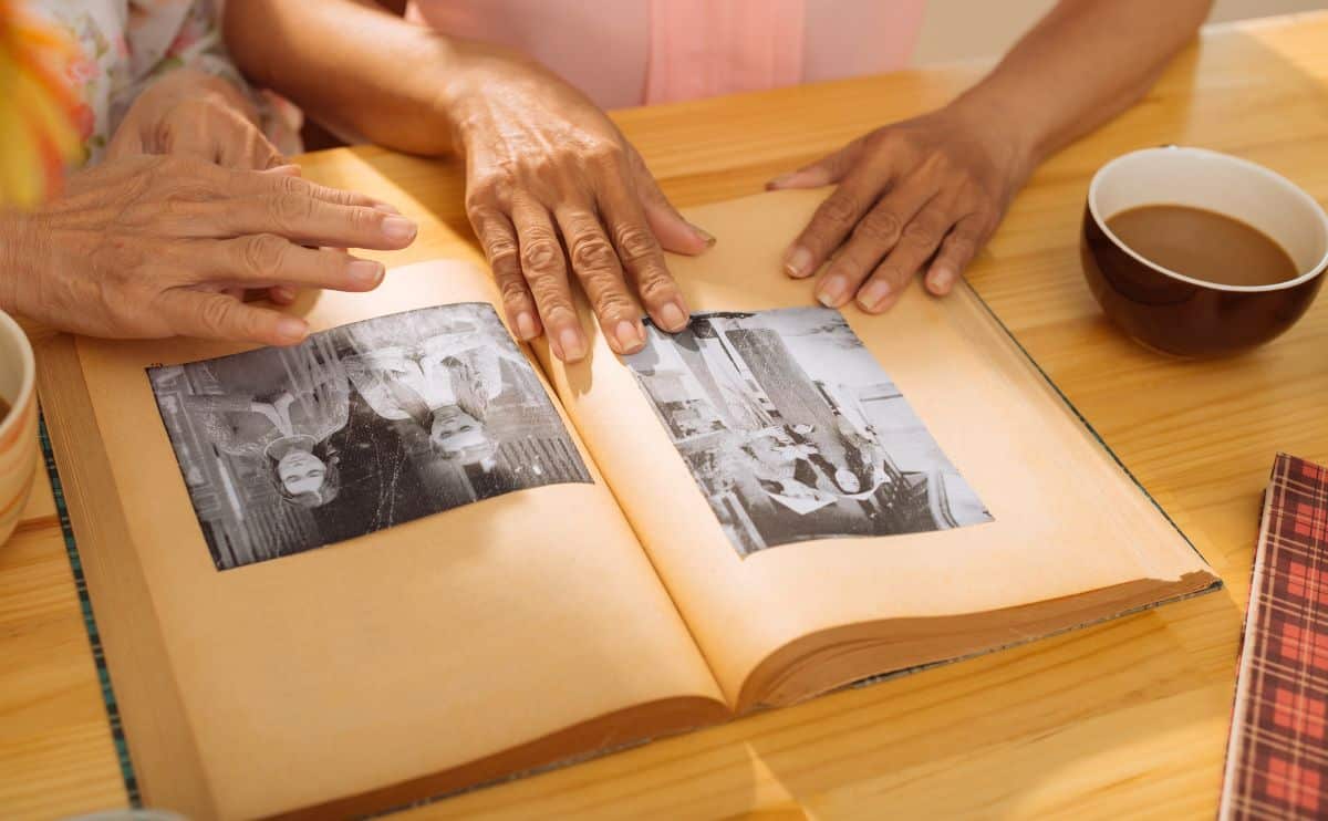 People reviewing old family photos in a scrapbook.