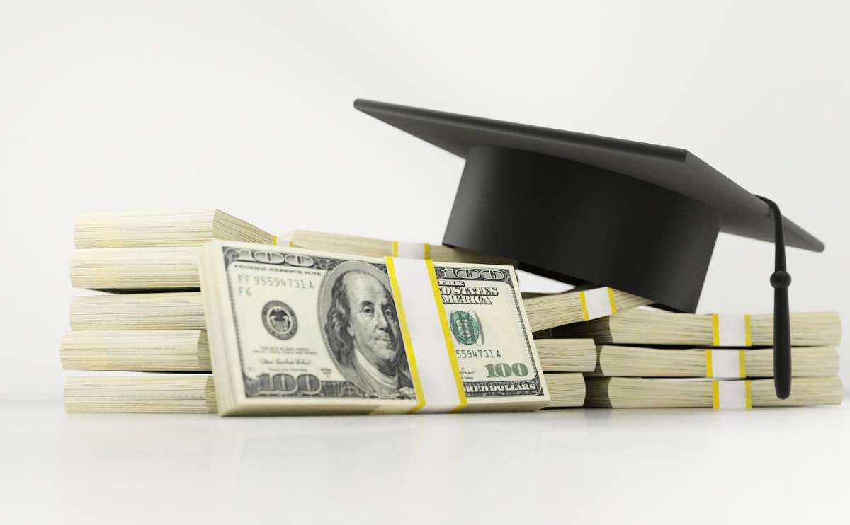 Pile of cash with college diploma hat on top.