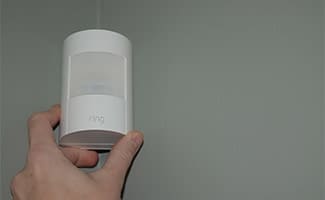 Hand placing a Ring Alarm motion detector