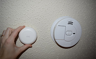 Hand placing a Ring Alarm Smoke & CO Listener