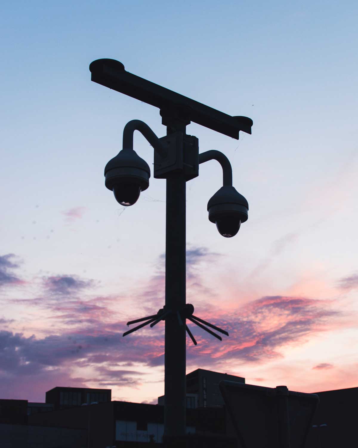 Security camera mounted on pole at sunset