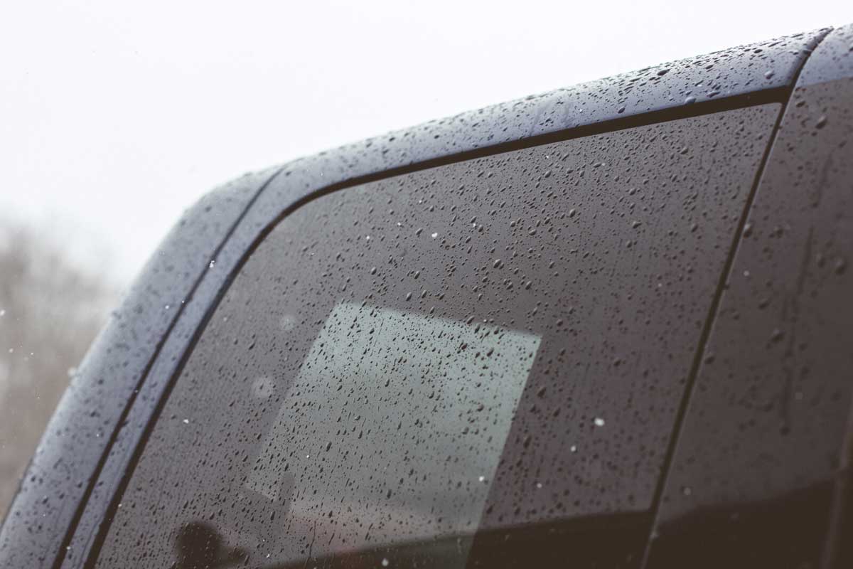 Tinted car window with raindrops