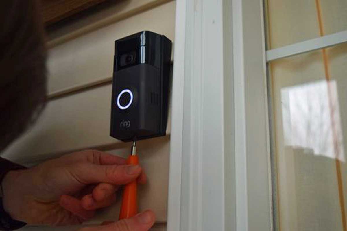 Close-up of hand using Ring provided hex screw driver to unlock Ring doorbell.