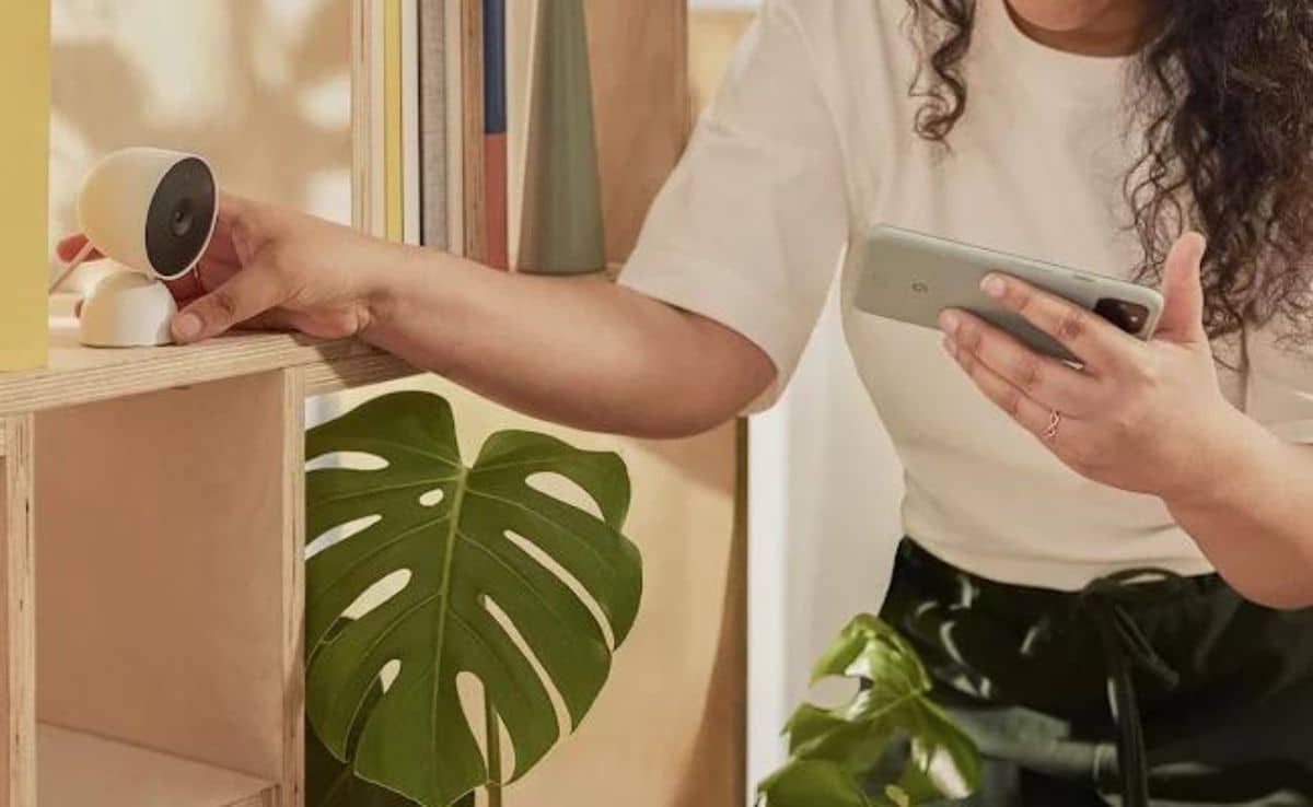 woman checking nest indoor camera via app jpg