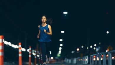 Woman jogging at night on a road.