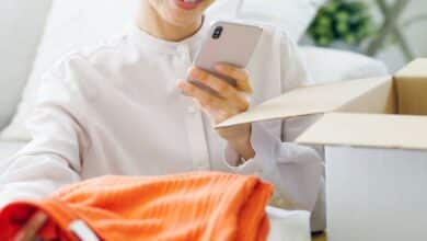 Woman looking at clothing subscription box taking photo.