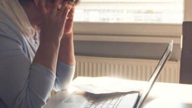 Woman struggling to read on a computer.