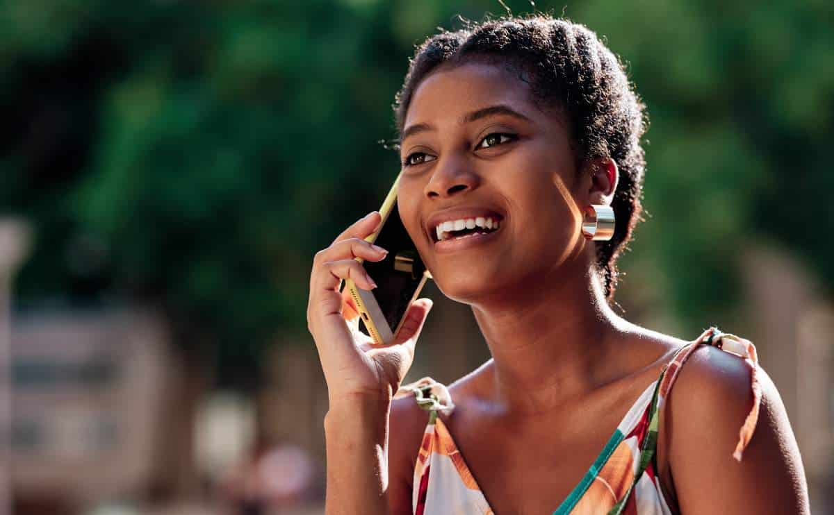 A woman talking on the phone while smiling.