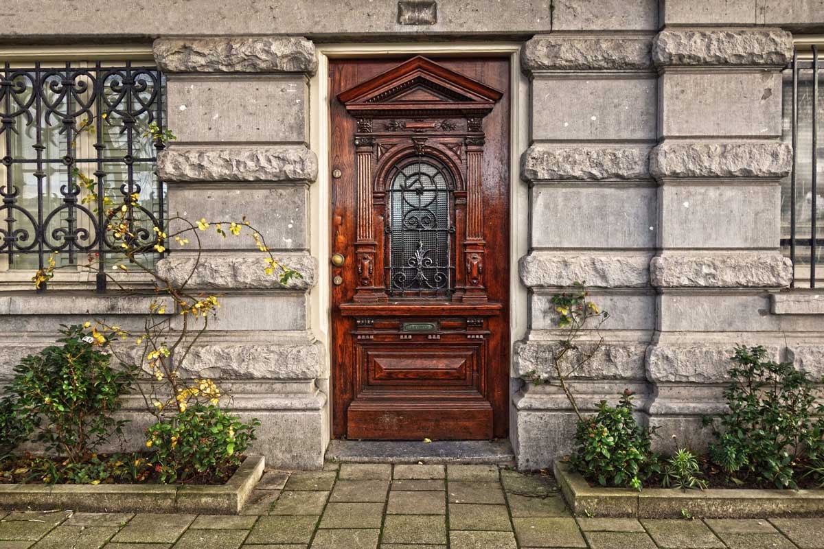 Wooden front door with stone and wrought iron trim